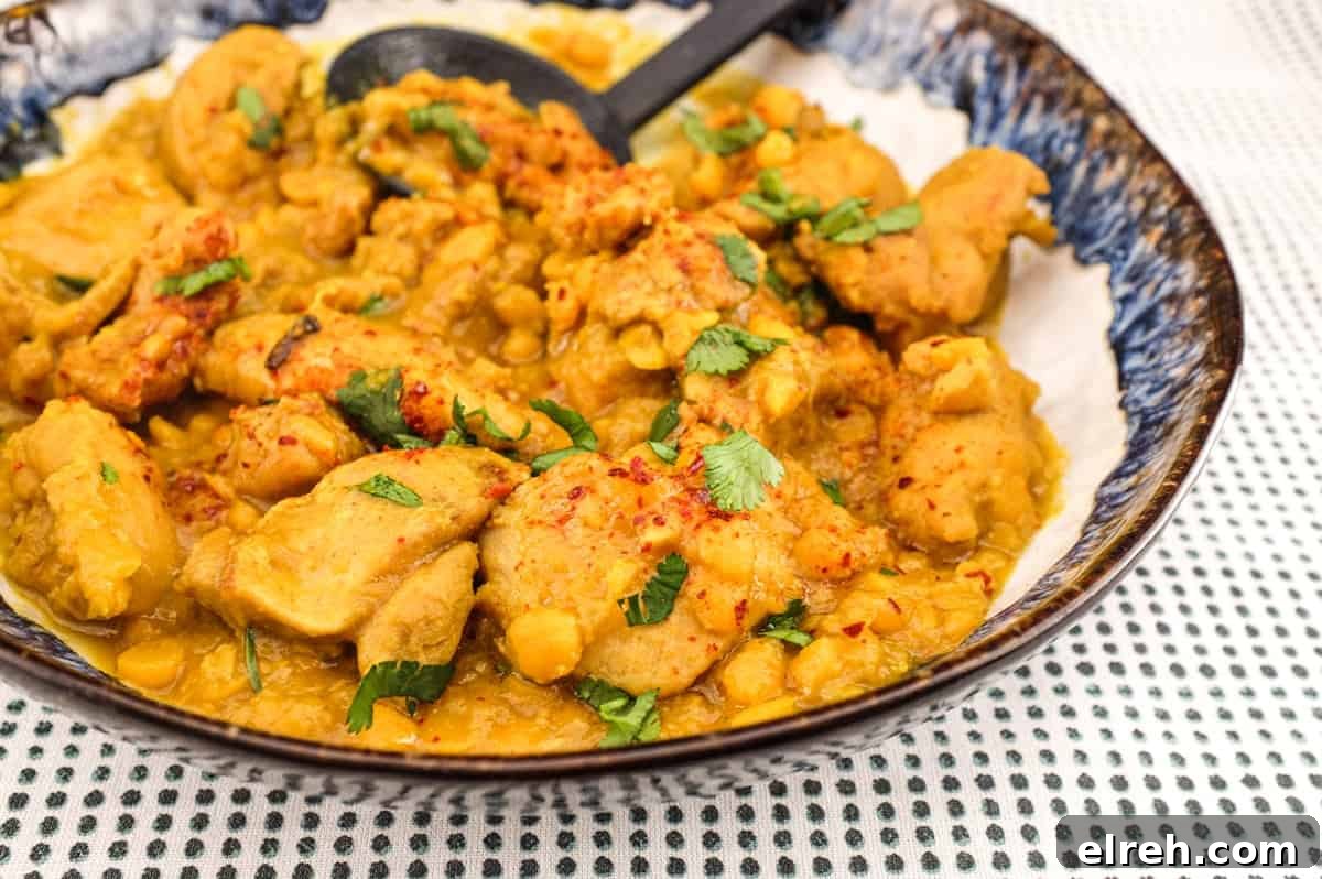 A plate of Pakistani Chicken Lahori curry with a black serving spoon