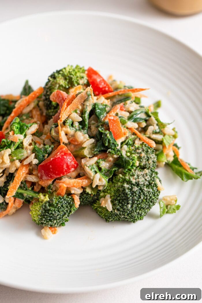 Broccoli, carrot and bell pepper salad with peanut sauce on a plate.