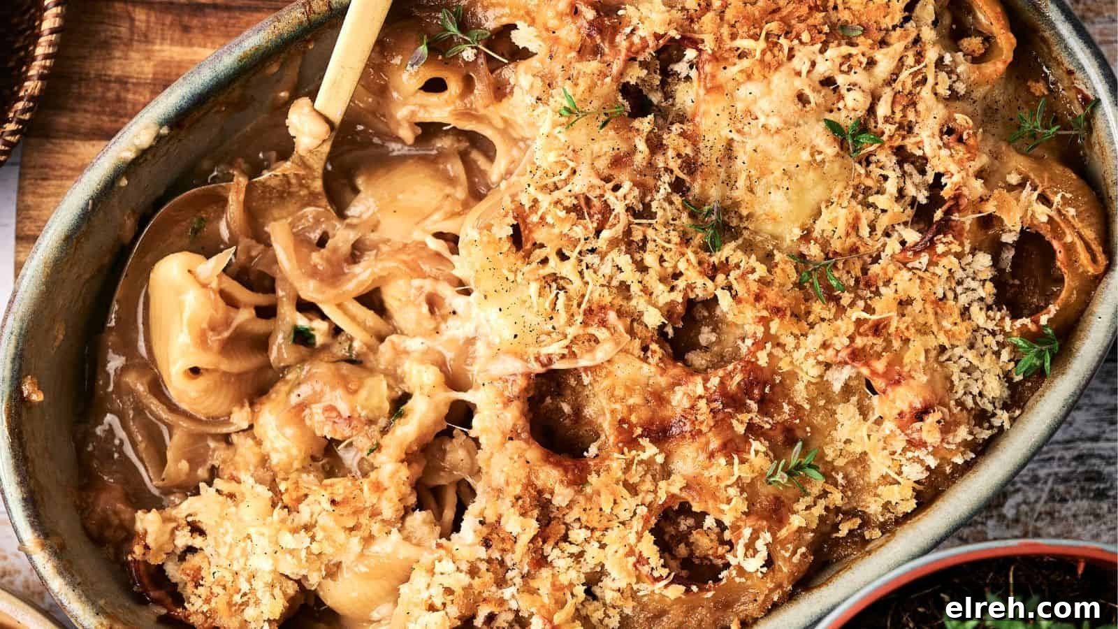 A baked casserole dish filled with creamy macaroni and cheese, topped with a golden-brown breadcrumb crust and garnished with fresh herbs.
