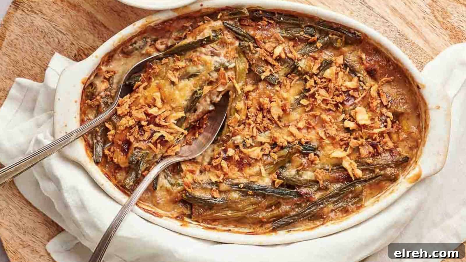 A casserole dish filled with green bean casserole with a spoon in it.