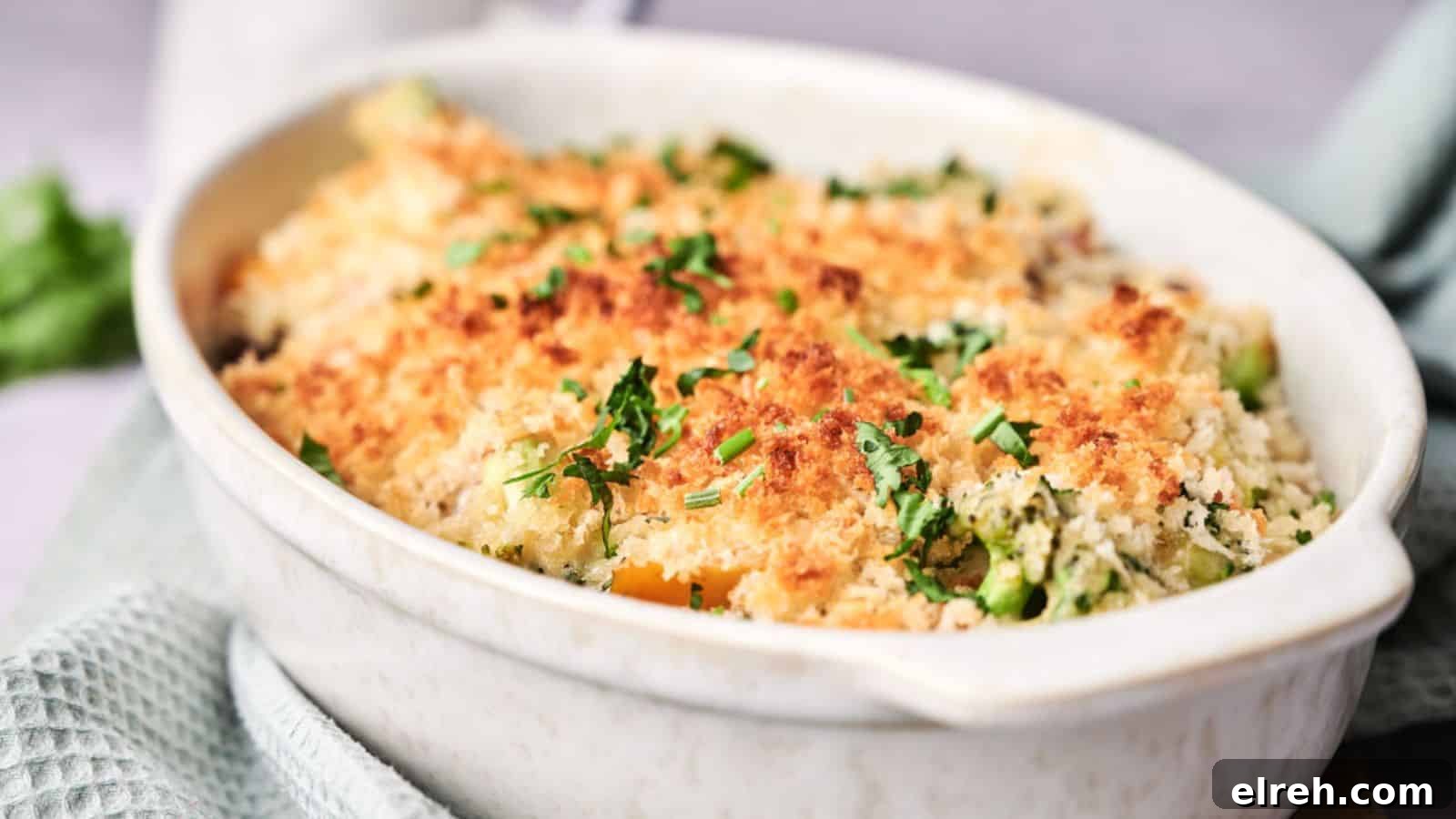 A baked casserole with a golden breadcrumb topping, garnished with fresh herbs.