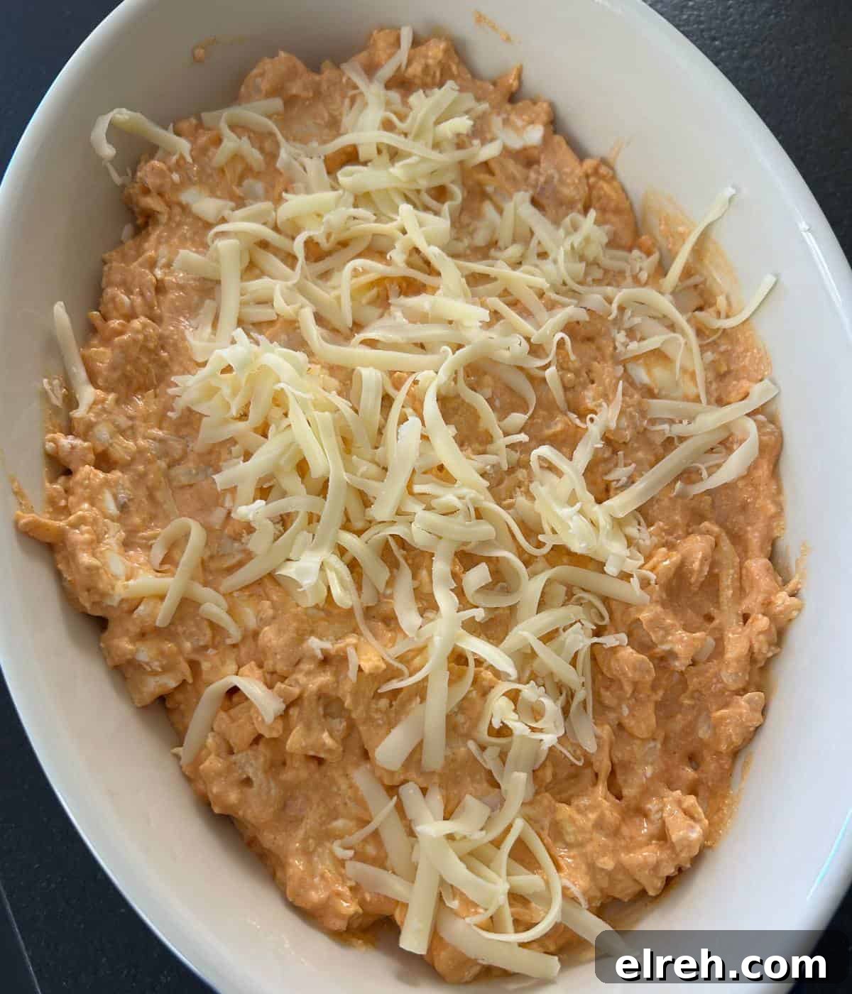 Creamy High-Protein Buffalo Chicken Dip with Cottage Cheese 8 Buffalo chicken dip in casserole dish topped with Monterey Jack cheese.