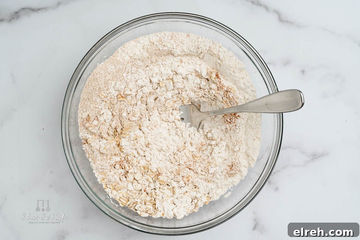 A clear bowl mixing all the dry ingredients.