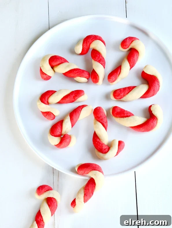 Overhead view of candy cane sugar cookies on white plate