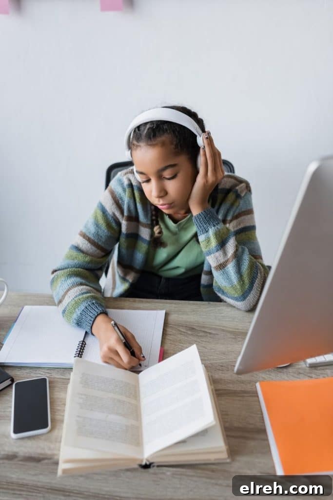 teenage girl studying while listening to headphones