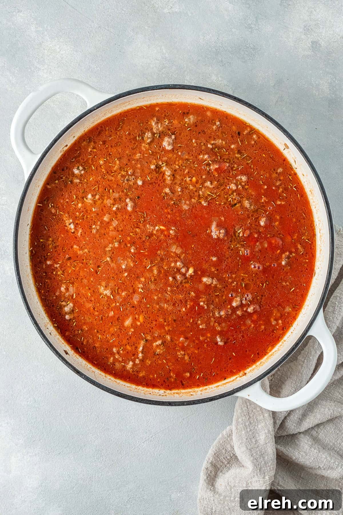 Adding the liquid to the pan with the beef.
