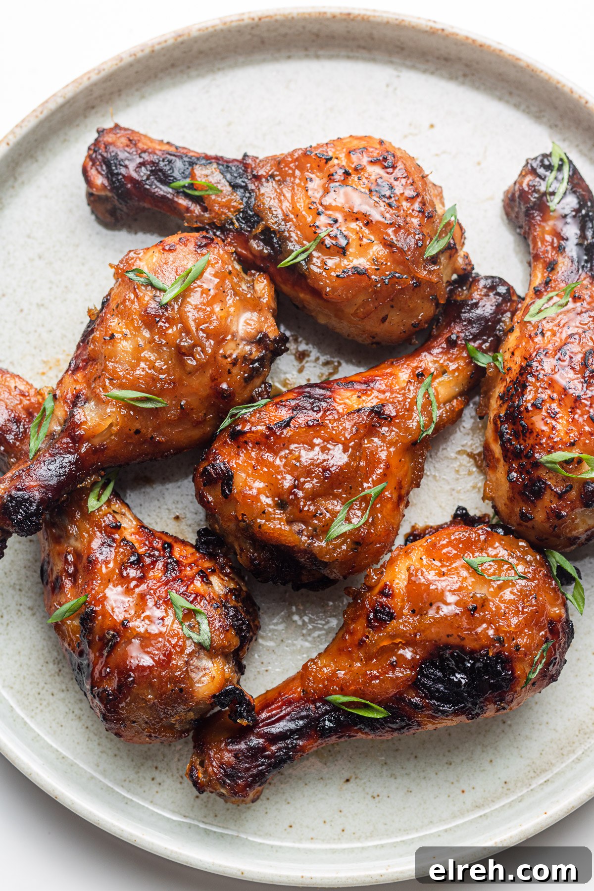 sticky asian chicken drumsticks on a ceramic plate