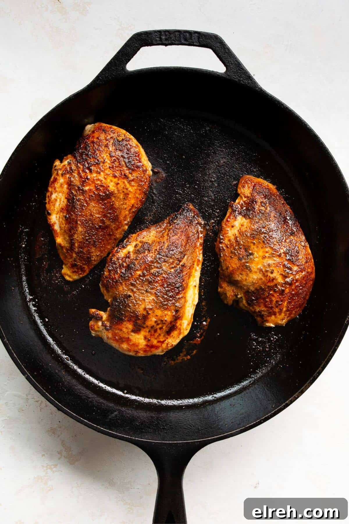 Chicken Fajita Tacos with Grilled Peppers and Onions 6 Searing three seasoned chicken breasts in a cast iron skillet.