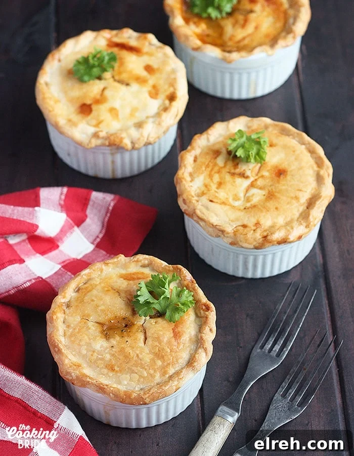 three baked crawfish pies on a wooden background with a red plaid napkin