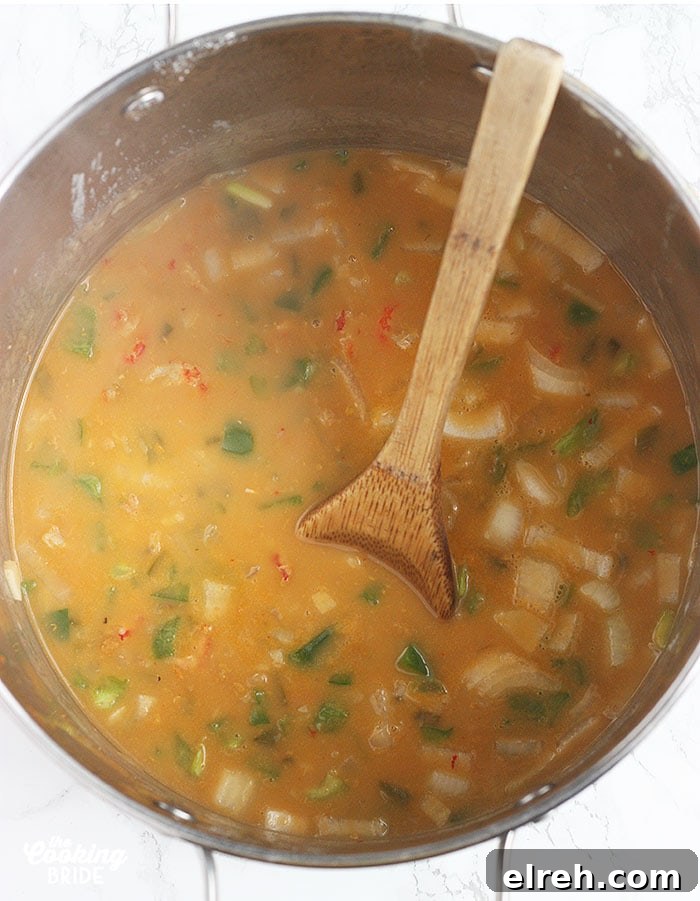 stirring crawfish filling in a stock pot with a wooden spoon