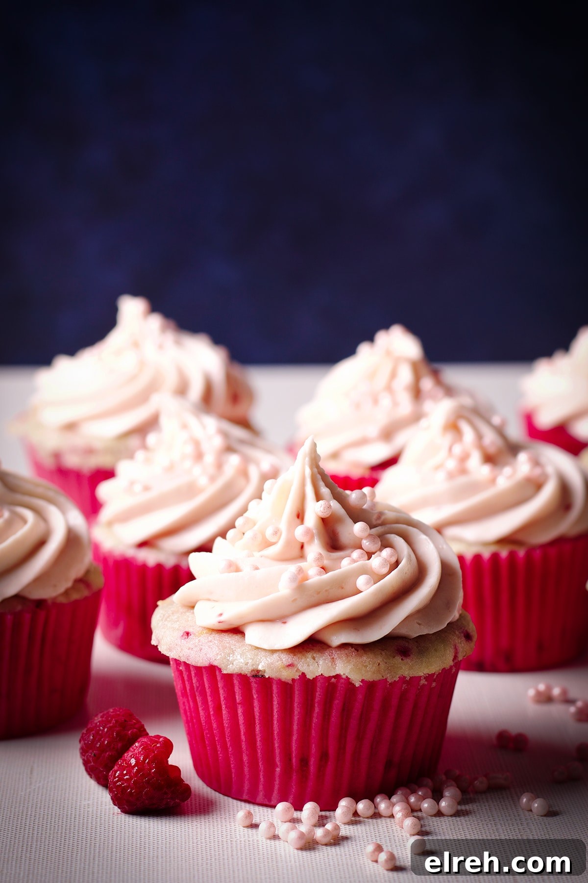 Raspberry Cupcakes Recipe with Cream Cheese Frosting 2 Several raspberry cupcakes topped with a swirl of raspberry cream cheese buttercream.