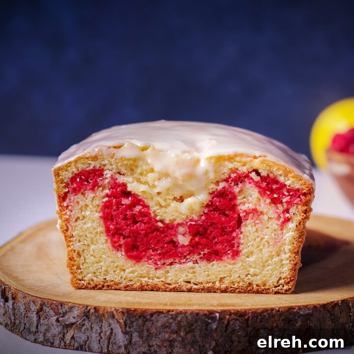 A raspberry swirl loaf cake on a wood cutting board.