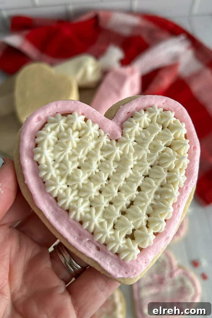 close up shot of a Valentines day cookie frosted with pink and white buttercream.