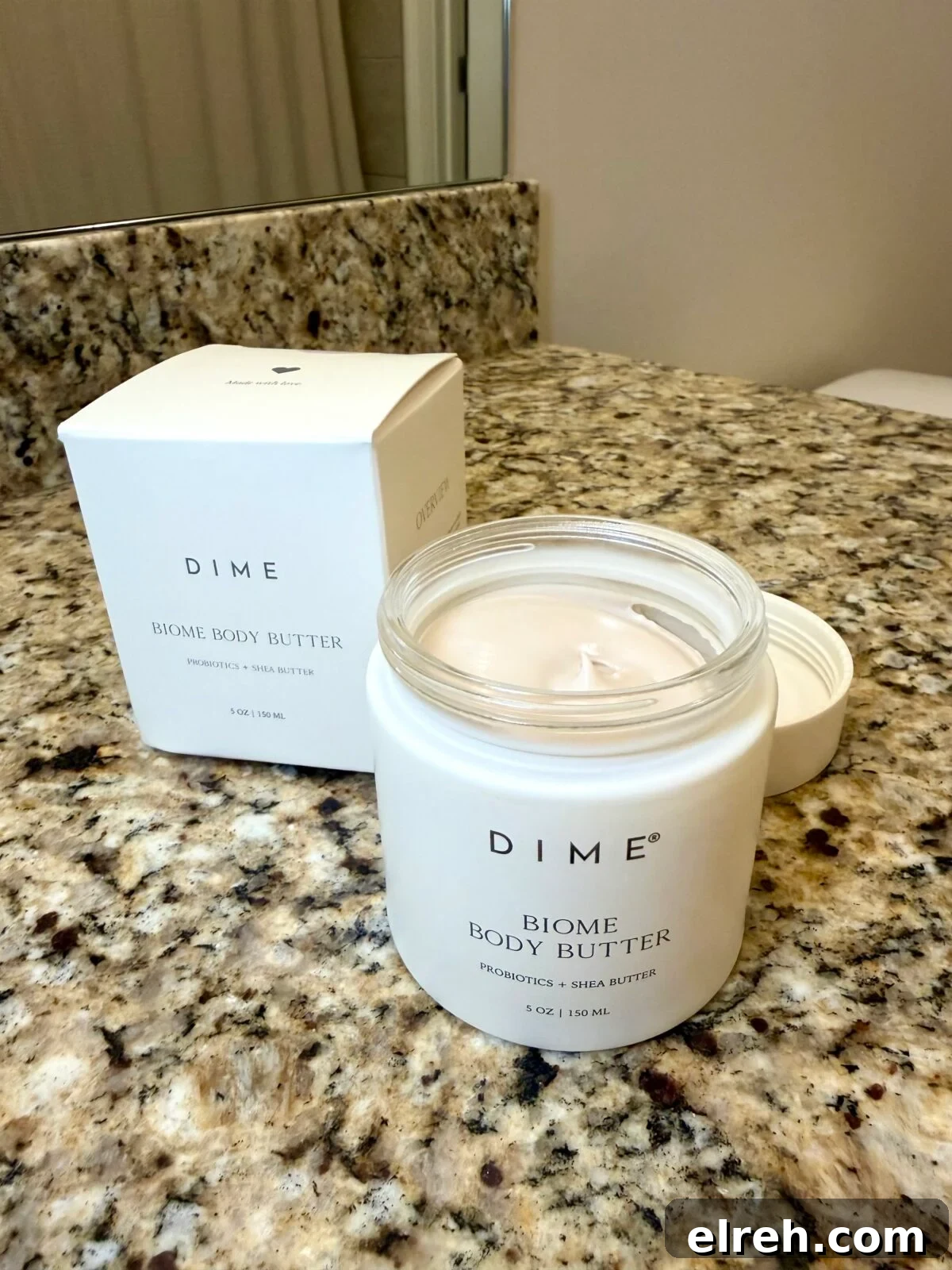 Open jar of DIME Biome Body Butter on a granite bathroom counter