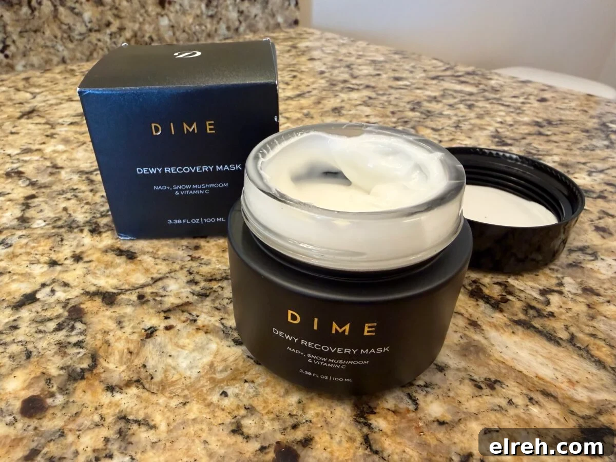An open jar of Dime Dewy Recovery Mask with its lid placed nearby