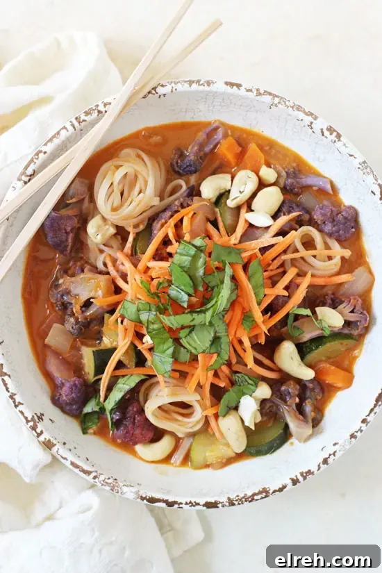 Rainbow vegetable curry noodle bowls ready in about 40 minutes with vegetables, noodles, and creamy curry broth. Overhead view of a rainbow vegetable curry noodle bowl with chopsticks balanced on the bowl.