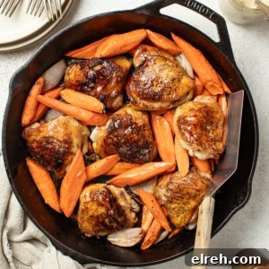 Crispy bone in chicken thighs and carrots in a cast iron pan with a spatula after being seared.