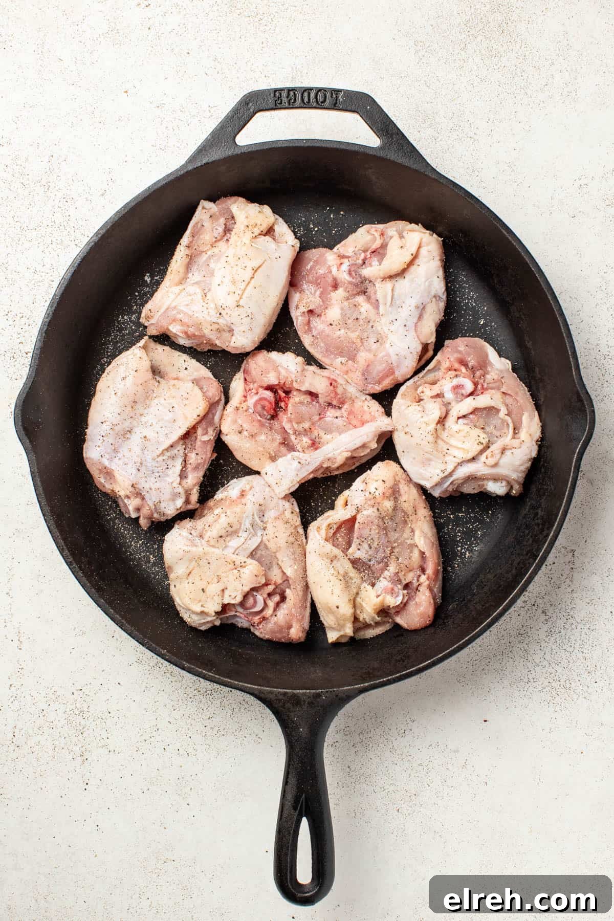 Searing chicken thighs skin side down in a cast iron pan.