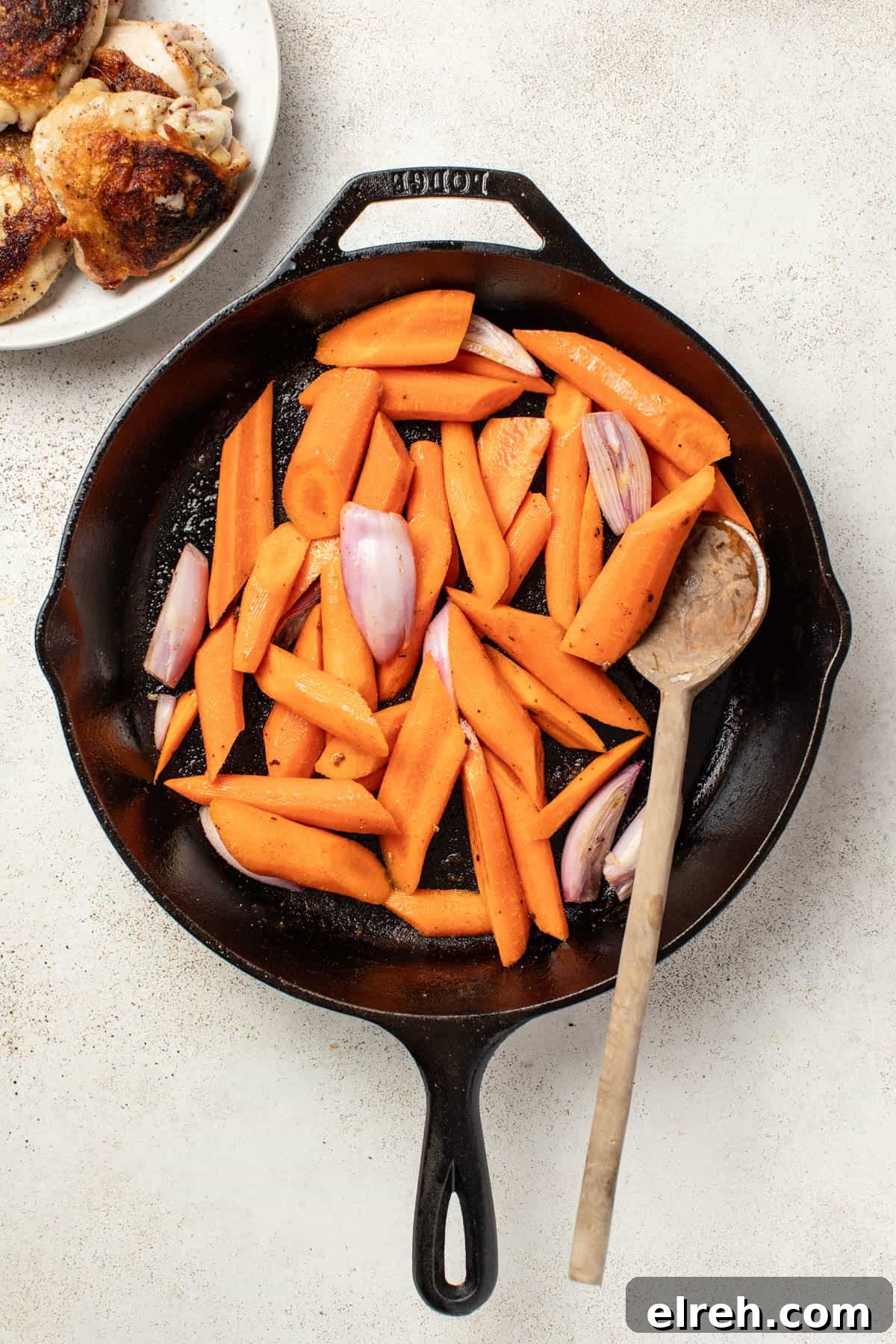 Cooking carrots and shallots in a cast iron pan.