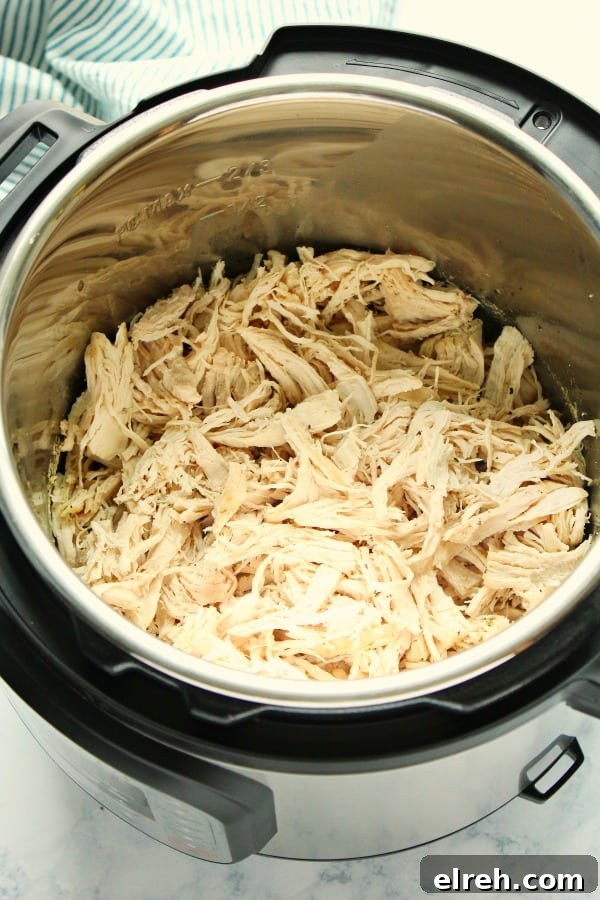 Instant Pot Shredded Chicken - easy way to cook fresh or frozen chicken breast into a juicy, flavorful shredded meat and use in many dishes, like tacos, BBQ chicken, Buffalo chicken, sandwiches or soups. Side shot of shredded chicken in Instant Pot.