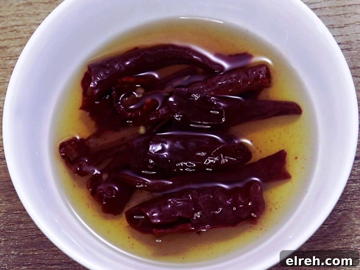 Authentic Homemade Harissa Sauce Recipe 3 image showing soaking red chillies in hot water in a small bowl.