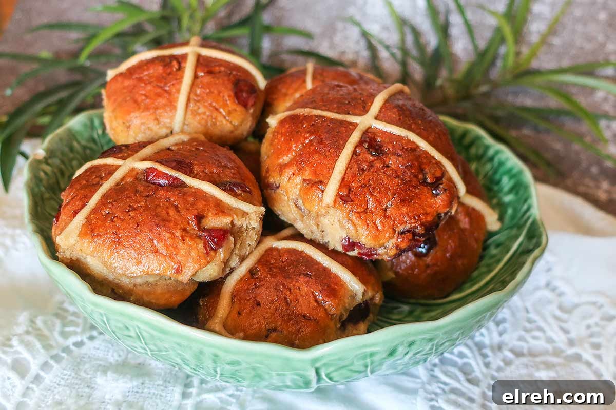 11 Gluten-Free Rolls and Buns: Soft, Fluffy Recipes 9 Soft, lightly sweet gluten-free hot cross buns with warm spices, orange zest, dried fruit, and a glossy apricot-glazed cross in a green bowl