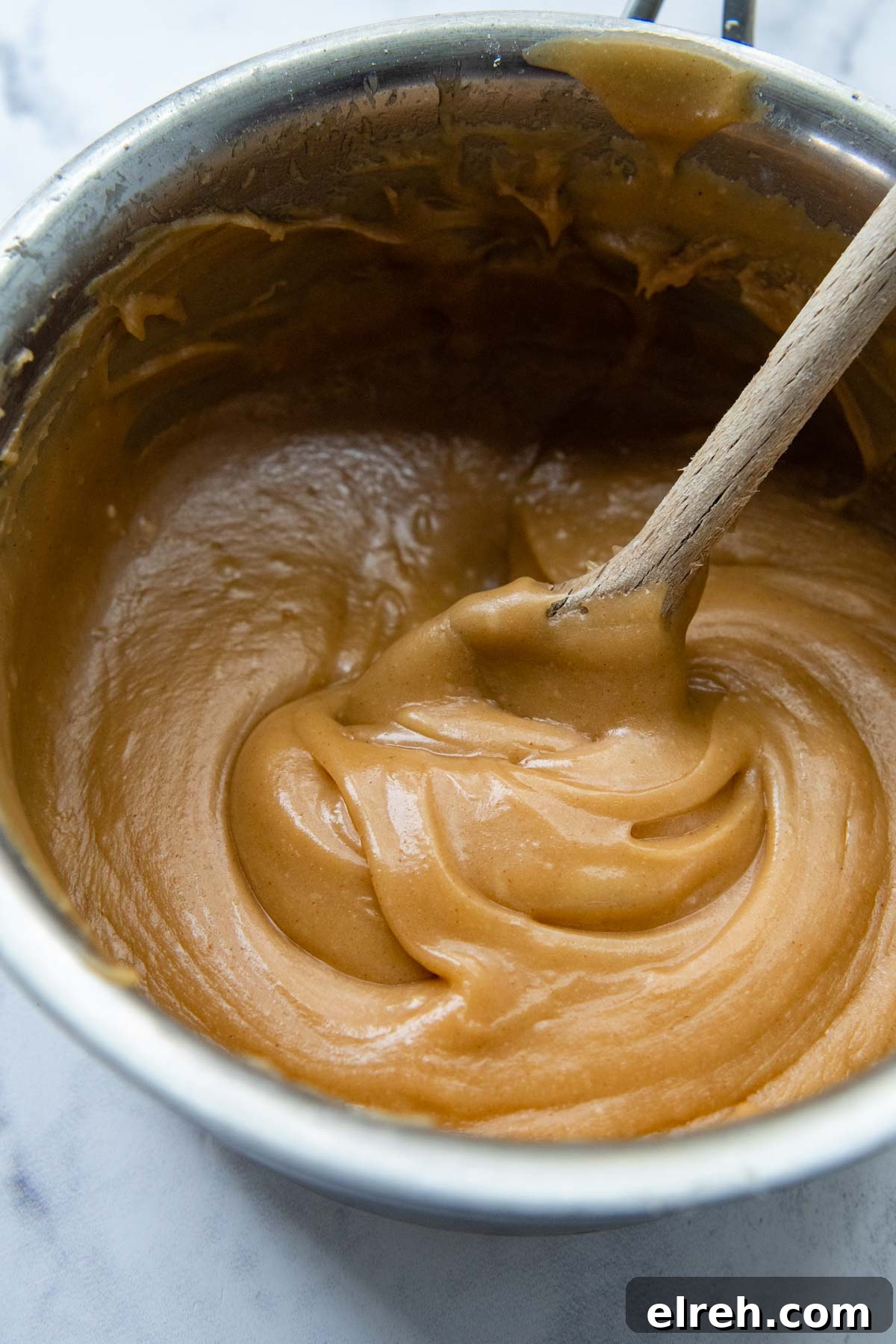 a saucepan with peanut butter glaze mixed inside.