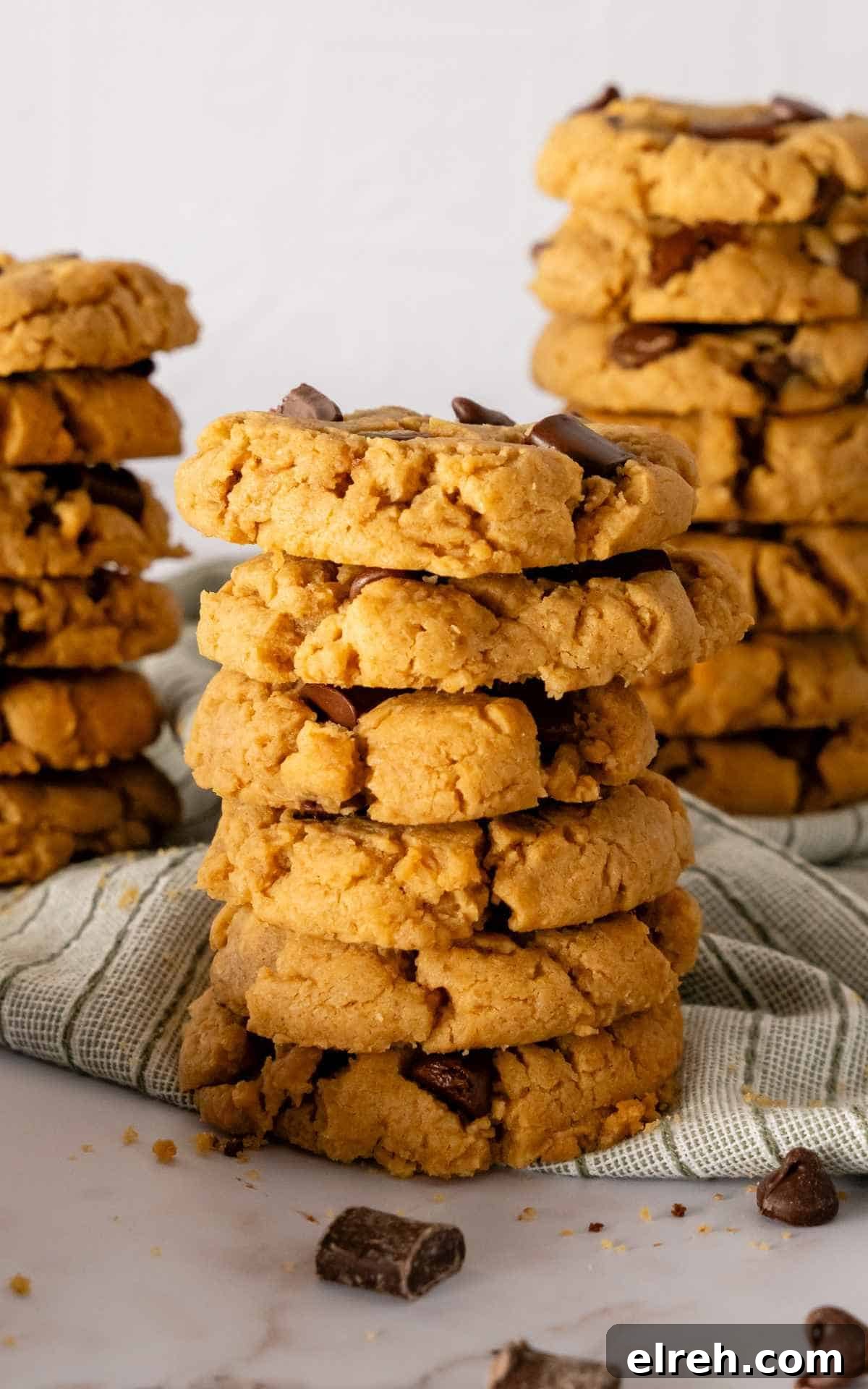 Chewy Peanut Butter Chocolate Chip Cookies Recipe 2 Peanut Butter Chocolate Chip Cookies stacked six cookies high with cookies in background.