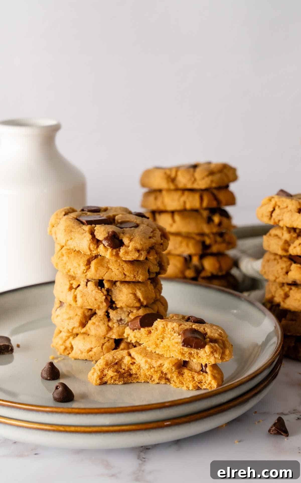 Chewy Peanut Butter Chocolate Chip Cookies Recipe 6 A plate with peanut butter chocolate chip cookies with a cookie broken in half.