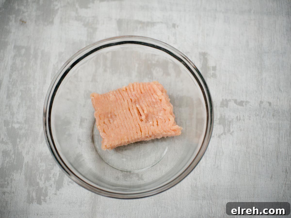 ground raw chicken in a glass bowl