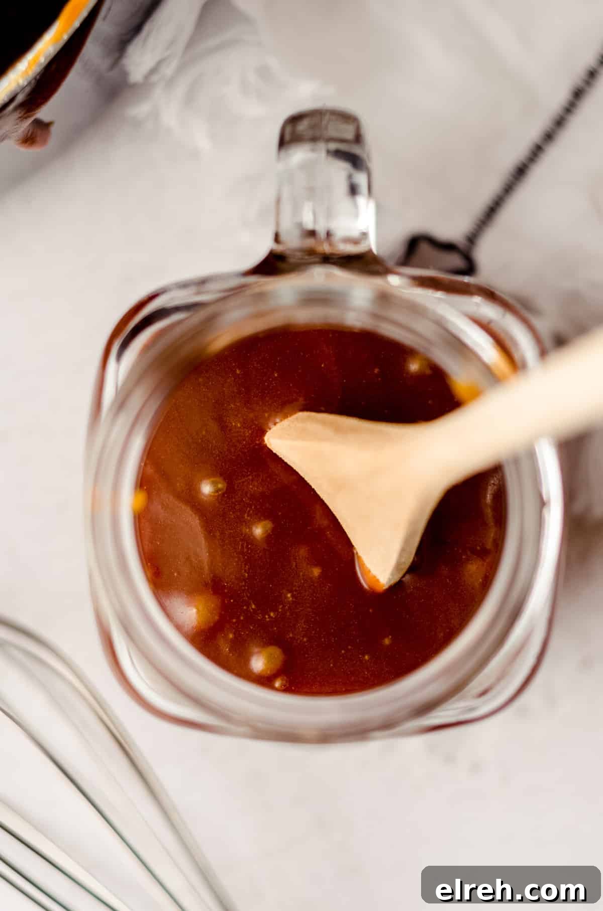 aerial photo of a jar of salted caramel sauce with a wooden spoon sitting in it