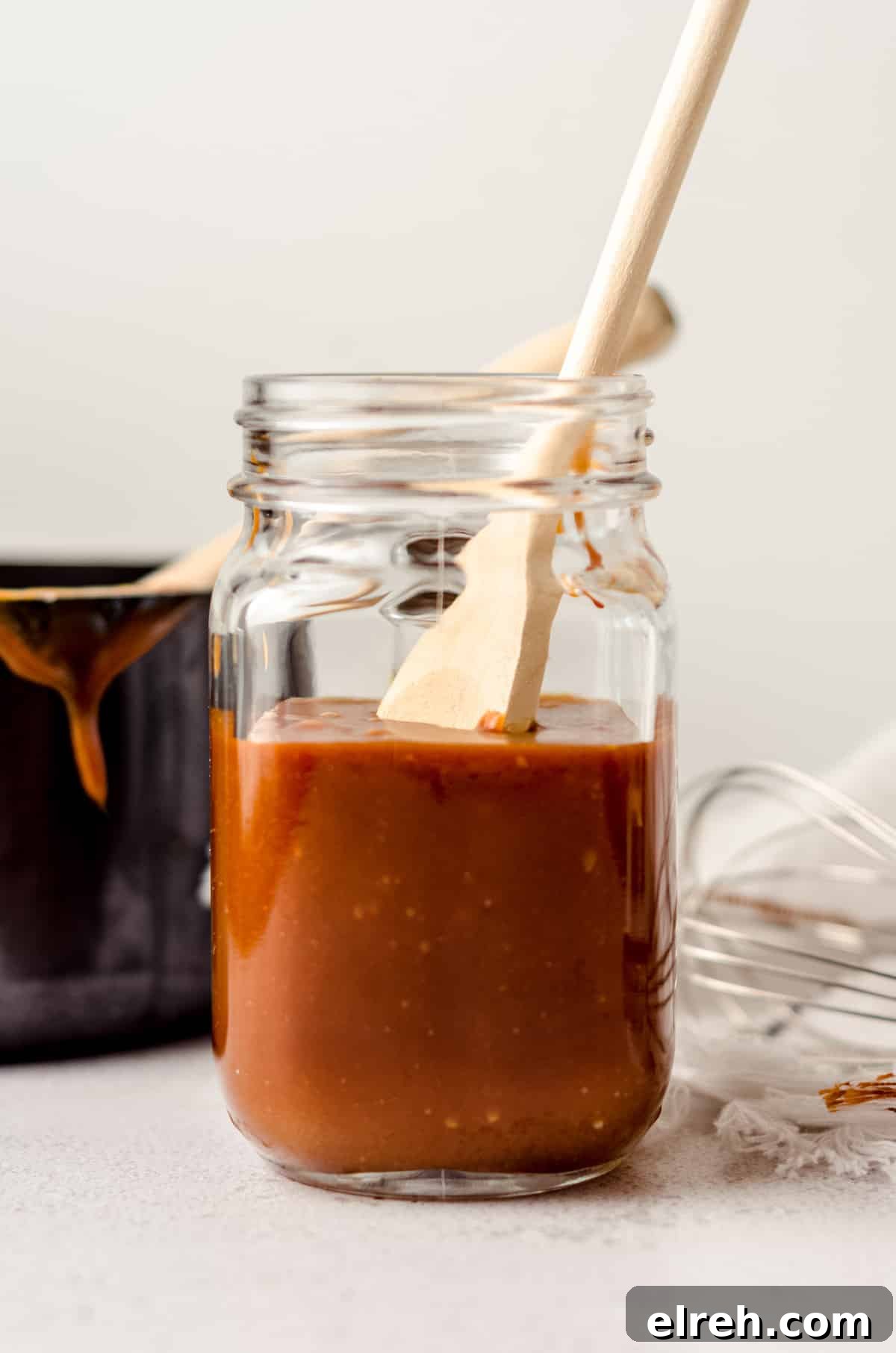jar of salted caramel sauce with a wooden spoon sitting in it