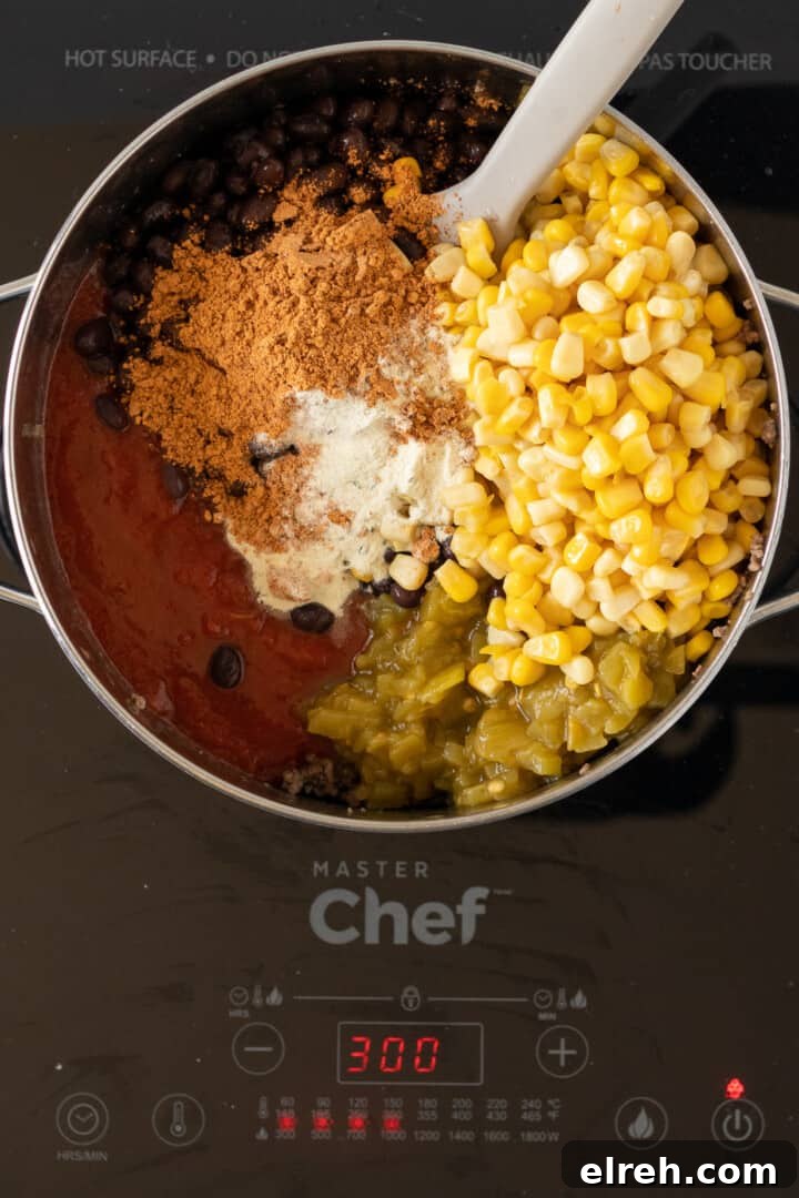 adding in remaining ingredients for taco soup.
