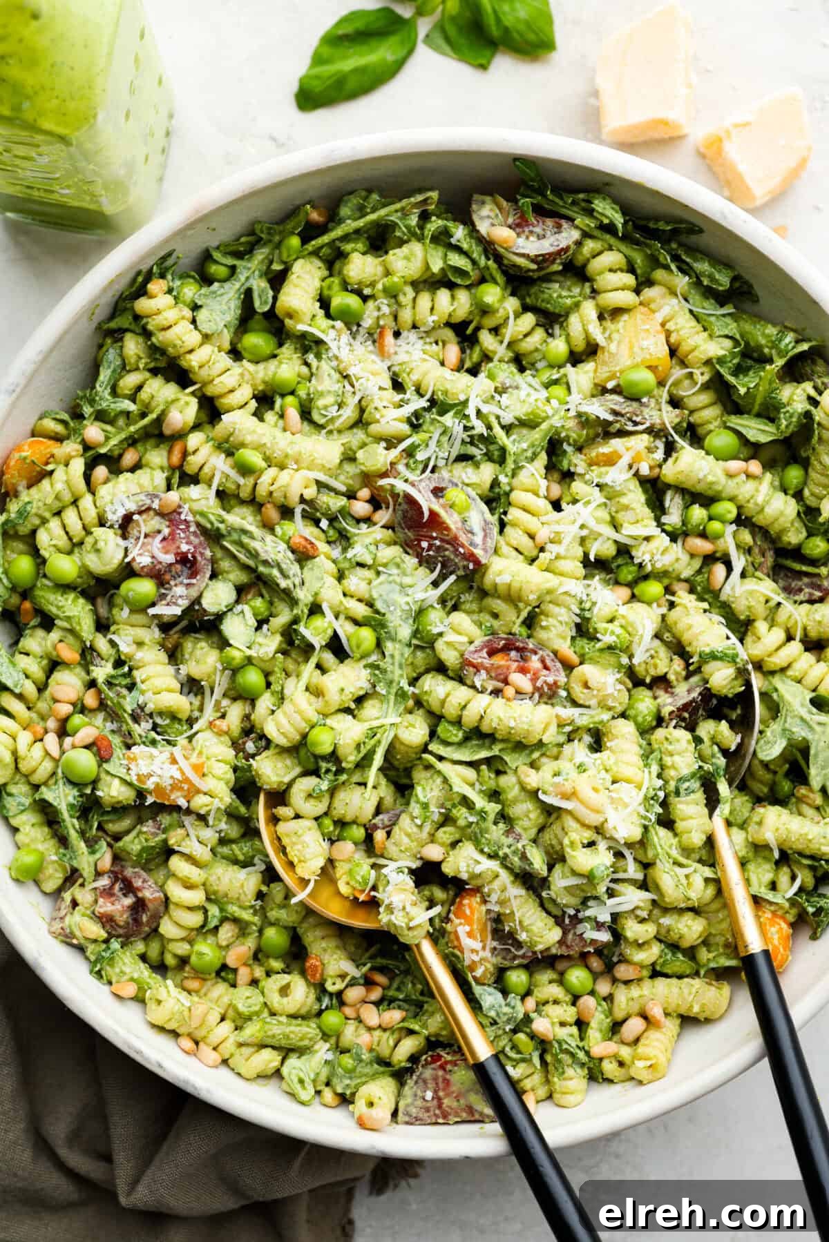 Creamy Green Goddess Pasta Salad with Avocado and Herbs 2 Overhead shot of green goddess pasta salad in a large serving dish with serving spoons.