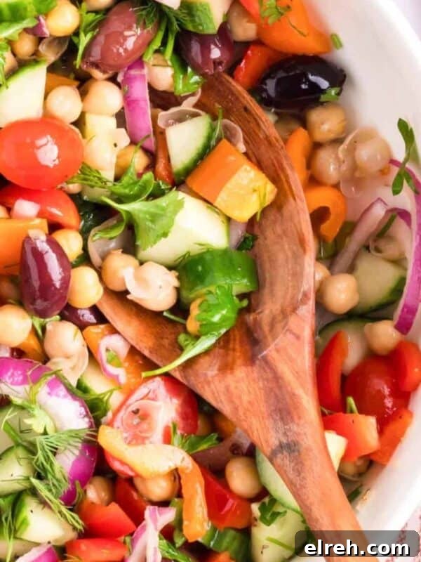Mediterranean Chickpea Salad in a white bowl with spoon