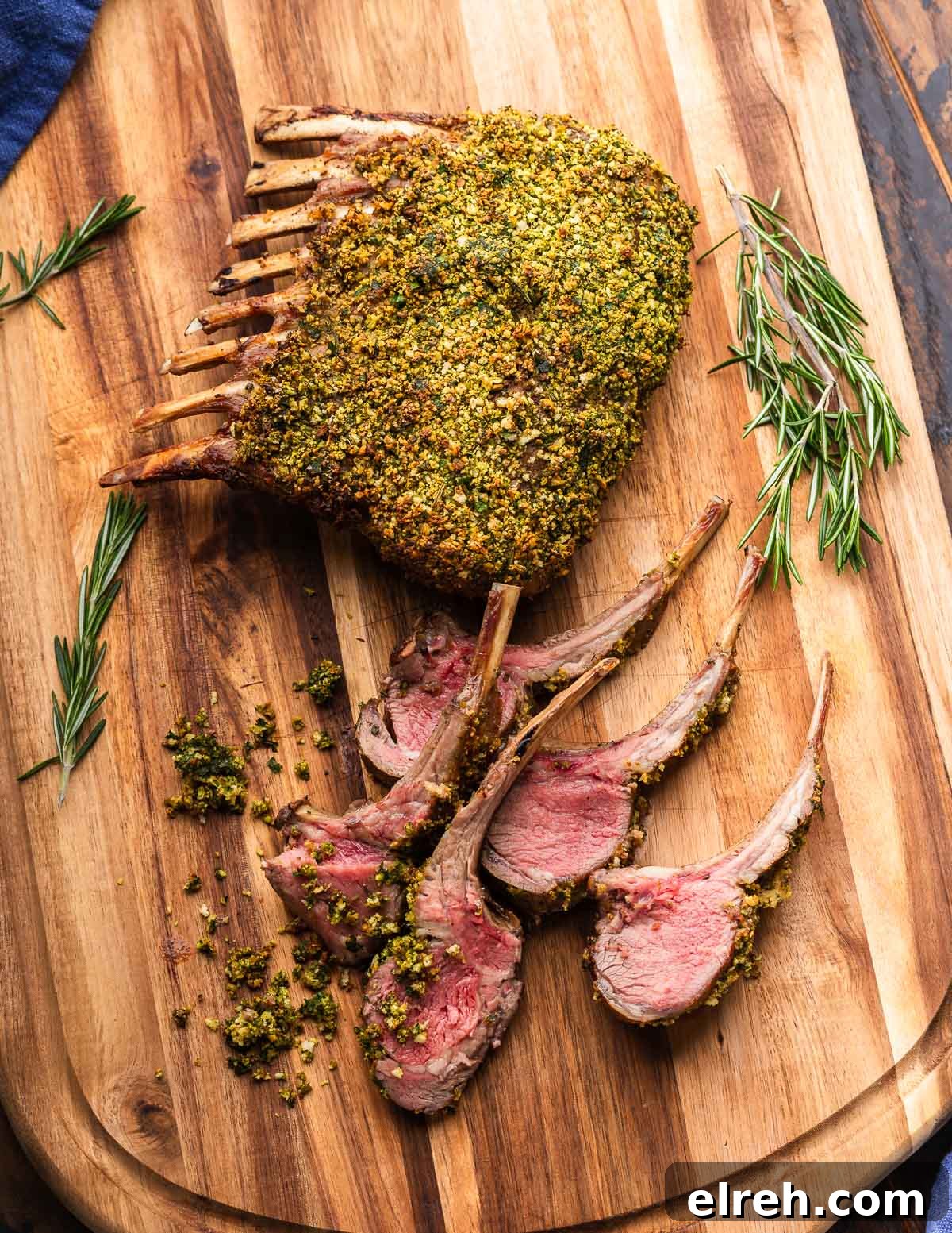Herb crusted rack of lamb sliced on cutting board.