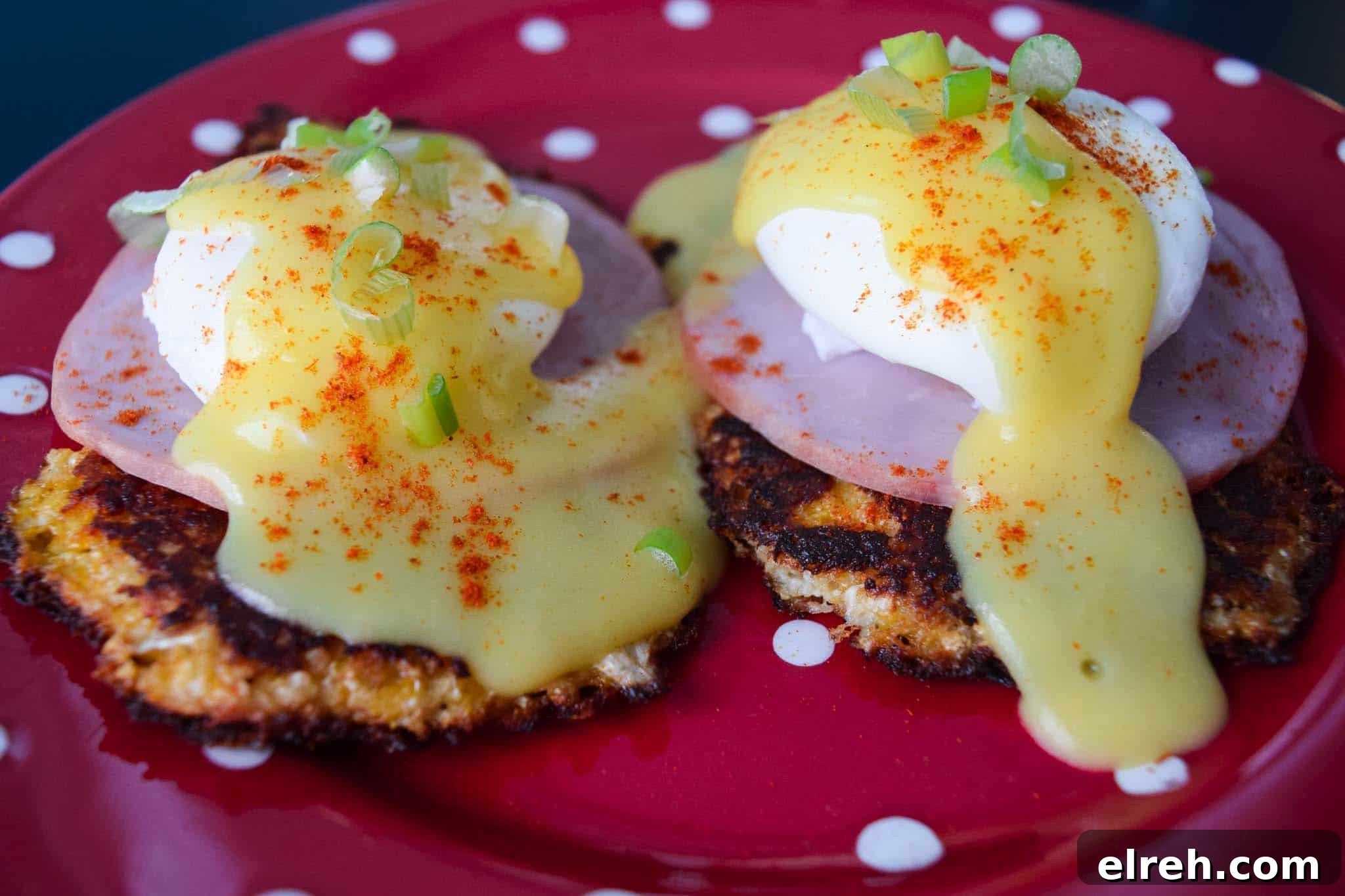 Cauliflower Eggs Benedict with Creamy Hollandaise 3 cauliflower benedict on red plate topped with hollandaise sauce close up