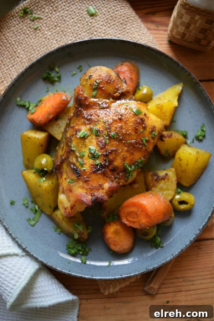 Sheet Pan Moroccan Chicken Dinner with Warm Spices 14 Moroccan chcken dinner on a blue plate.