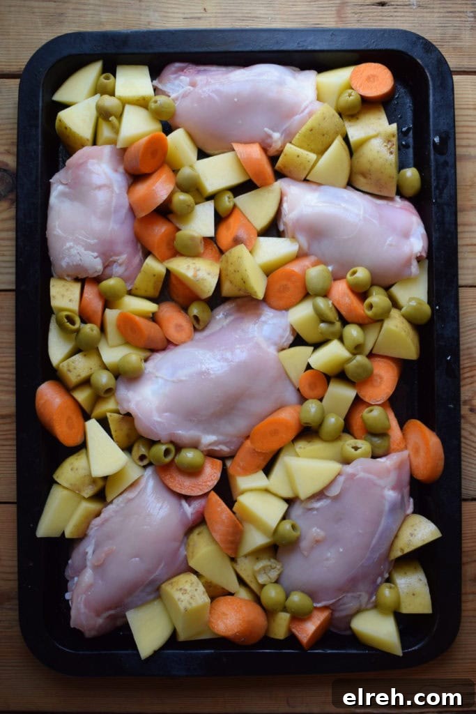 Sheet Pan Moroccan Chicken Dinner with Warm Spices 8 Chicken, vegetables and olives on a baking tray.