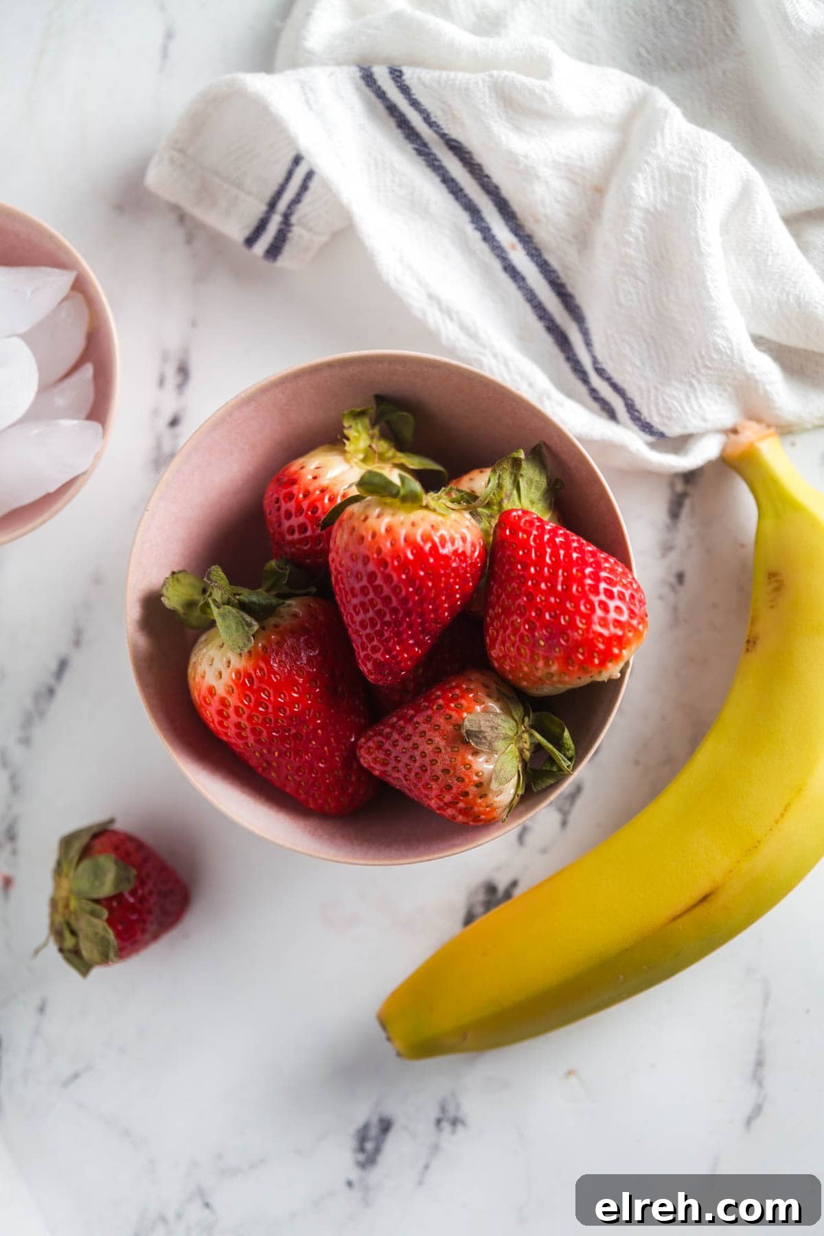 Flatlay of ingredients needed to make homemade strawberry banana smoothies.
