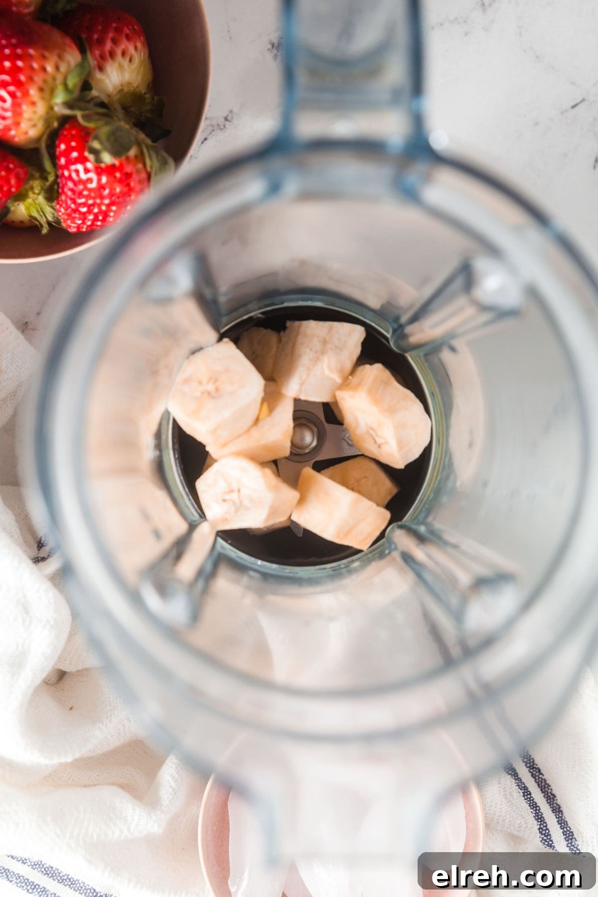 Adding bananas to a blender to make smoothies.