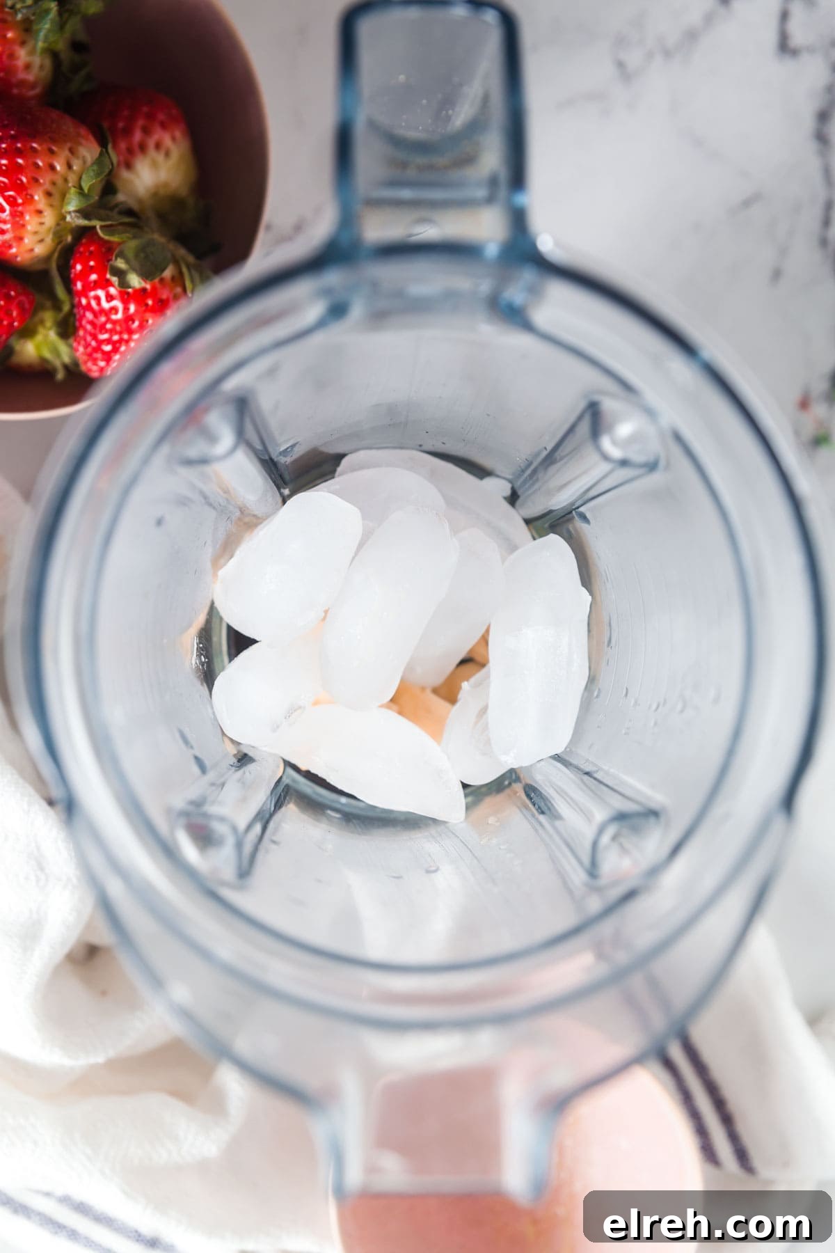 Adding ice to the blender to give this homemade smoothie a frozen, frothy texture.