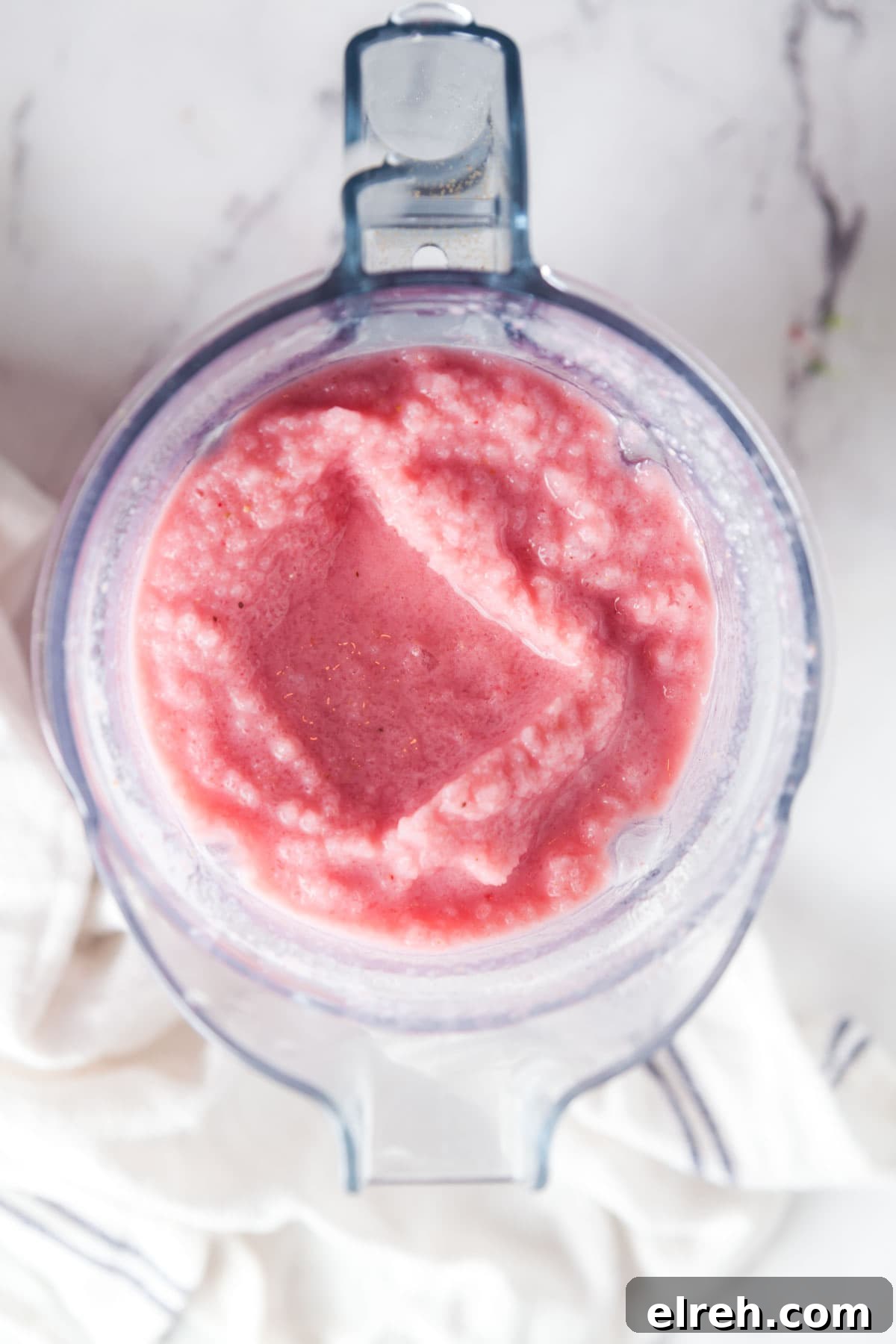 Overhead view of a blender filled with strawberry banana smoothie.