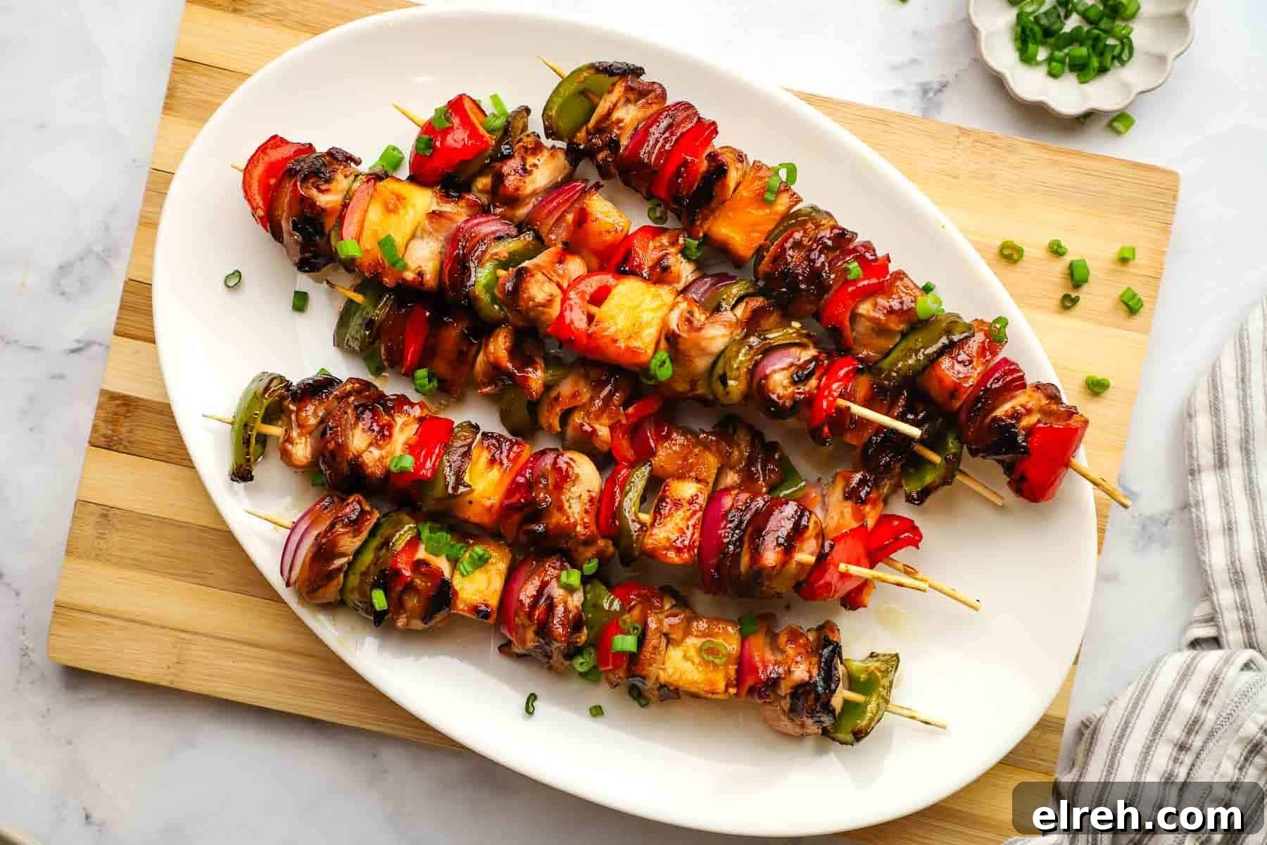 a platter of teriyaki chicken and vegetable skewers.