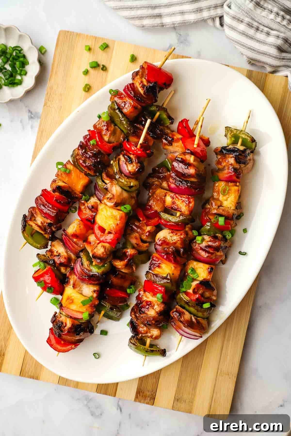 A platter of teriyaki chicken and vegetable skewers.
