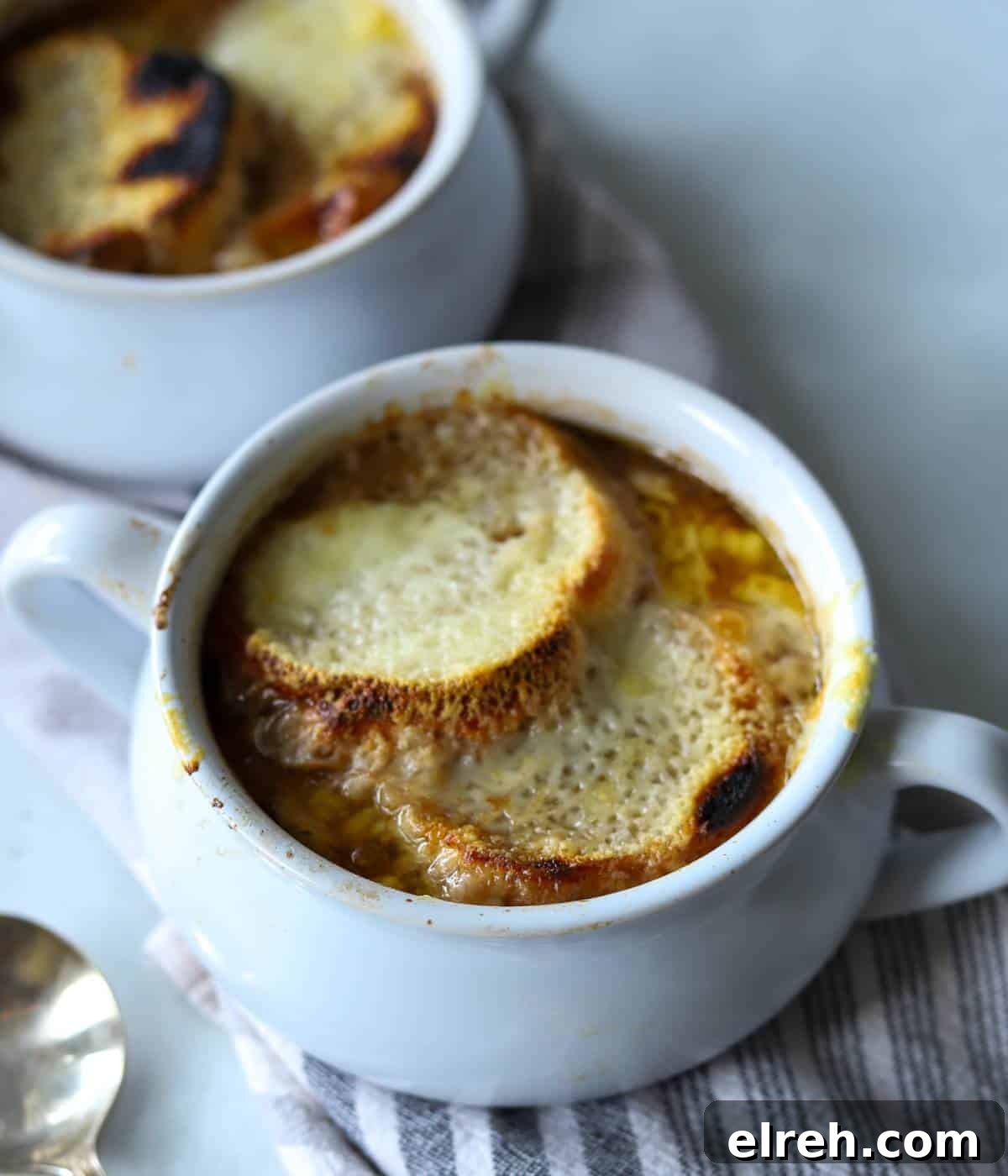 Panera Copycat French Onion Soup Recipe - Bistro-Style 2 French onion soup in soup bowl with bread and cheese.
