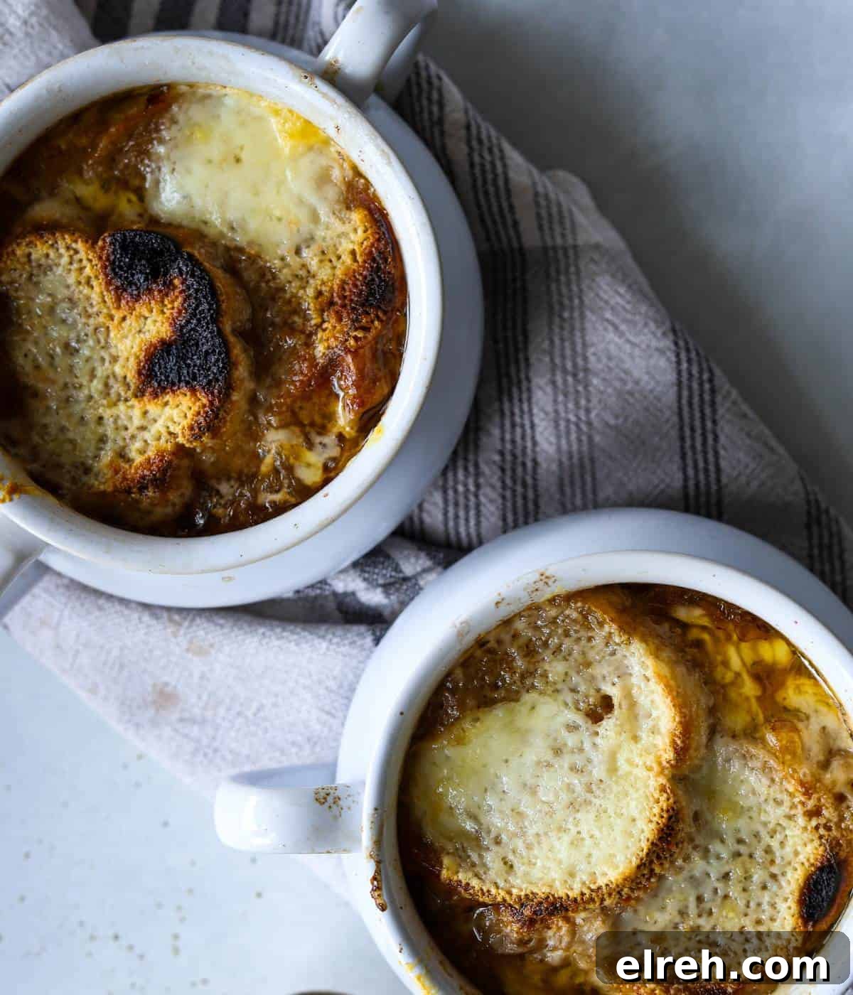 Panera Copycat French Onion Soup Recipe - Bistro-Style 11 Two soup bowls filled with cheese.