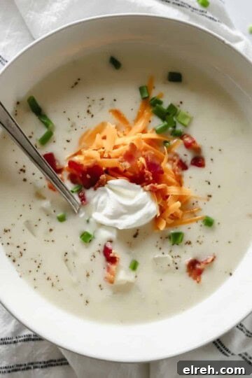 bowl of loaded baked potato soup topped with cheese, sour cream, bacon and chives