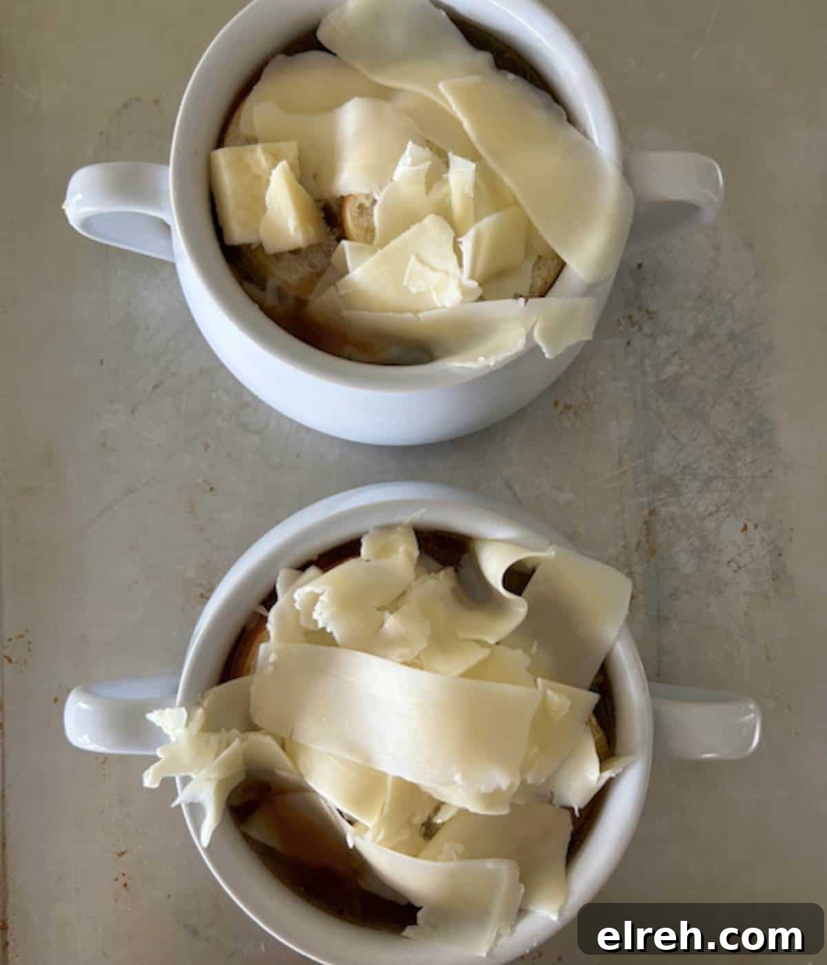 Panera Copycat French Onion Soup Recipe - Bistro-Style 10 Two soup bowls full of French onion soup topped with bread and cheese.