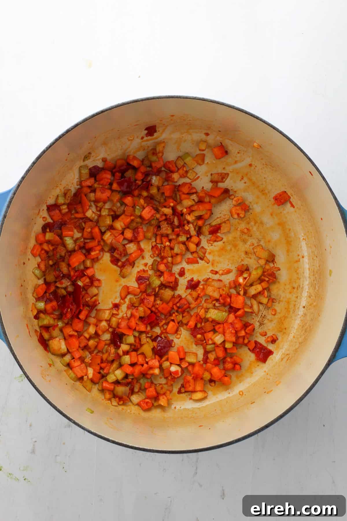 A Dutch oven with sautéed carrots, celery, garlic, Calabrian peppers and tomato paste.